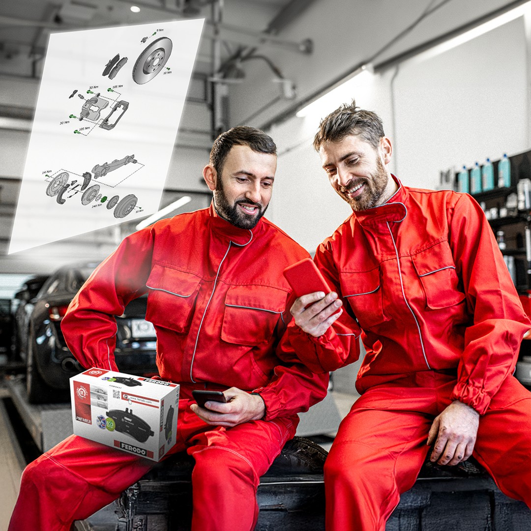 Dos mecánicos de automóviles examinan en un taller los planos técnicos detallados de Ferodo a los que se accede escaneando un código QR de Ferodo en el embalaje del producto.